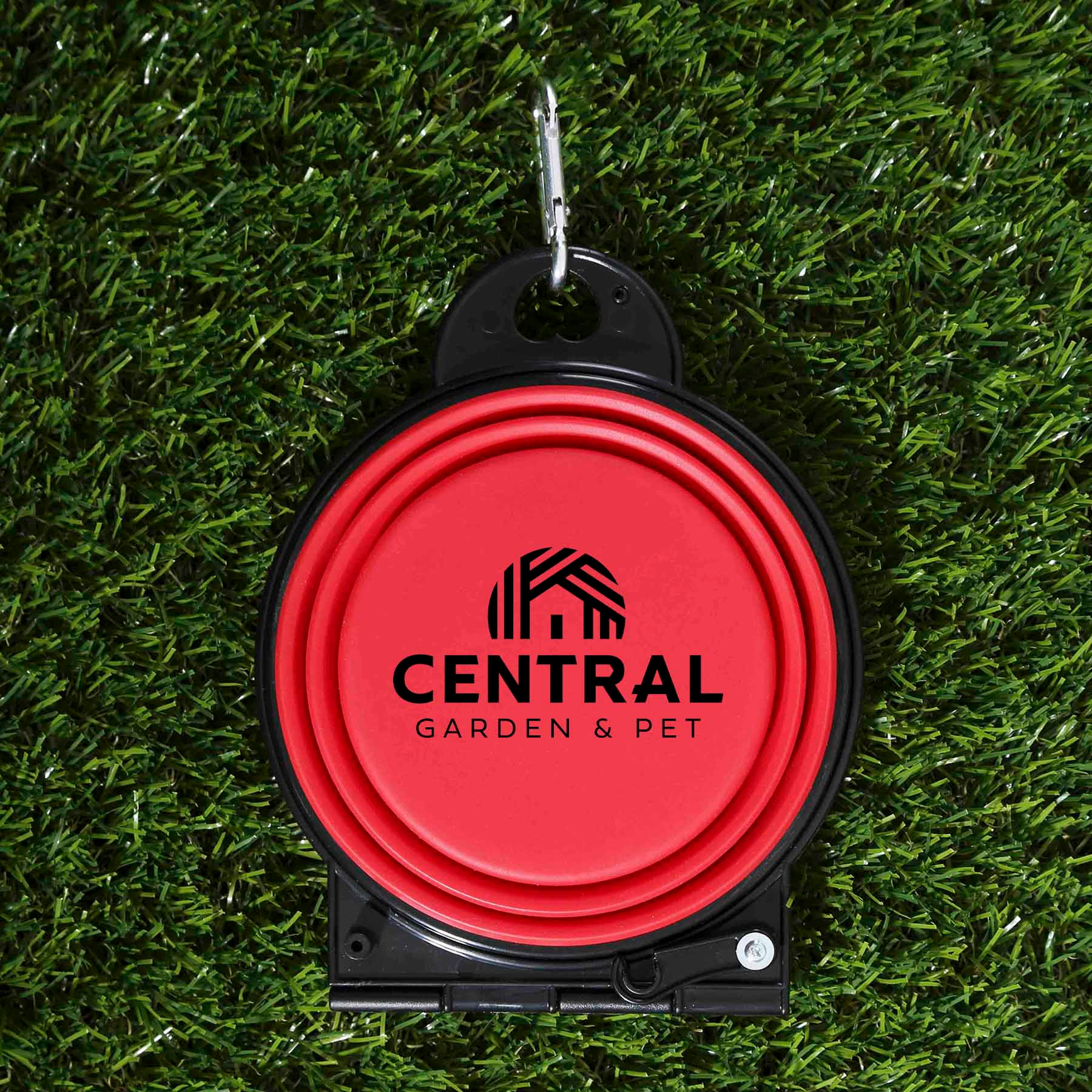 A Red dual collapsible pet bowl made of flexible silicone in a two-tone design, shown in a travel setting with one side used for food and the other for water, demonstrating its portable use for feeding pets on outdoor walks or trips.