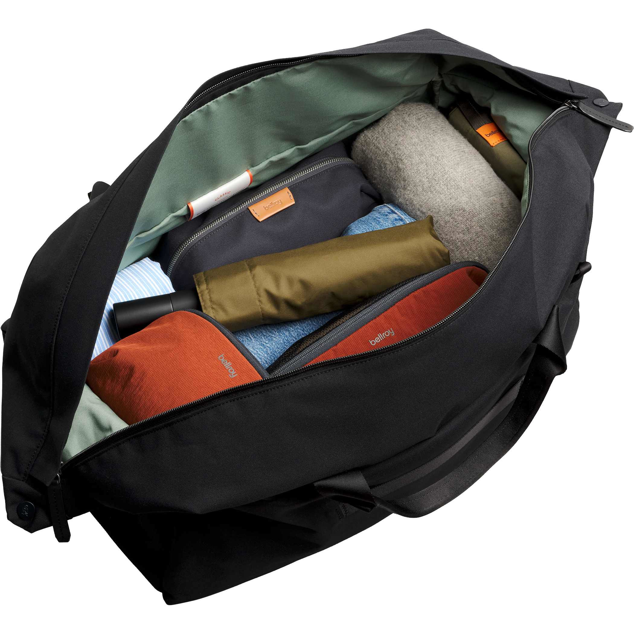 Bellroy Classic 45L Duffle Bag in black Canva Weave fabric packed with clothing and travel essentials, featuring a wide-opening barrel design, organized interior pockets, and spacious storage for weekend travel and everyday carry.
