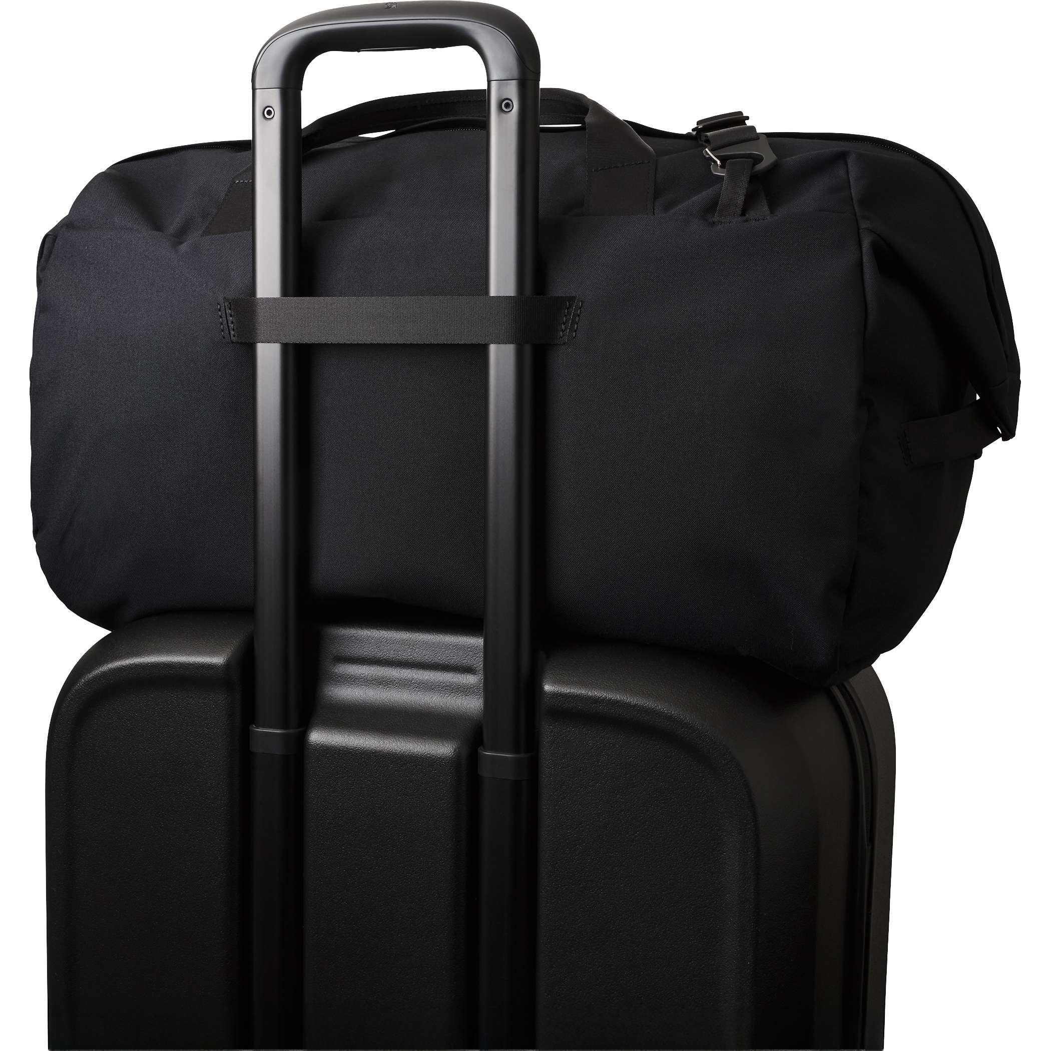 Black Bellroy Classic 45L Duffle Bag in black recycled fabric resting on rolling luggage in a travel setting, featuring barrel-shaped construction, dual carry handles, detachable shoulder strap, and spacious design for weekend travel and everyday carry.