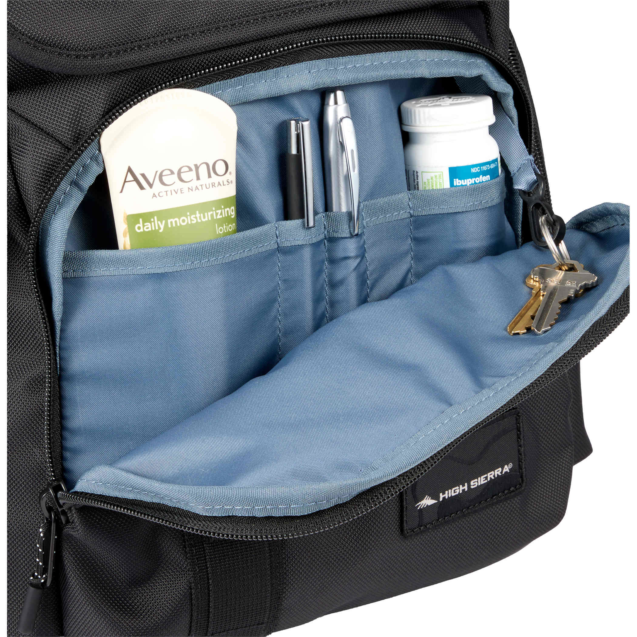 High Sierra Trekpoint Flap Backpack in black recycled polyester with blue interior organizer pocket holding pens, keys, and small essentials, highlighting organized everyday carry storage.