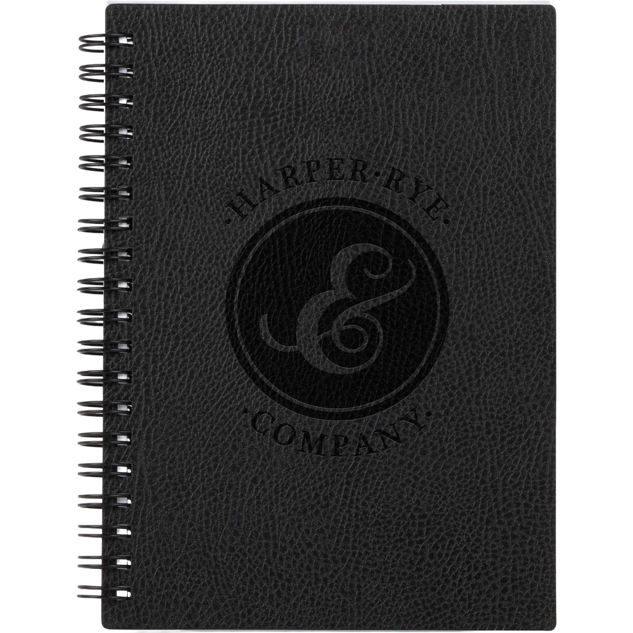 Black 5” x 7” Pebble Grain FSC® Recycled Spiral Journal with textured recycled polyurethane cover, spiral binding, lined recycled paper pages, and matching elastic pen loop, designed for everyday note-taking, journaling, and office use.