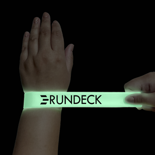 Glow-in-the-dark snap bracelet made of flexible vinyl material that lights up after exposure to light, designed for parties and promotional events.