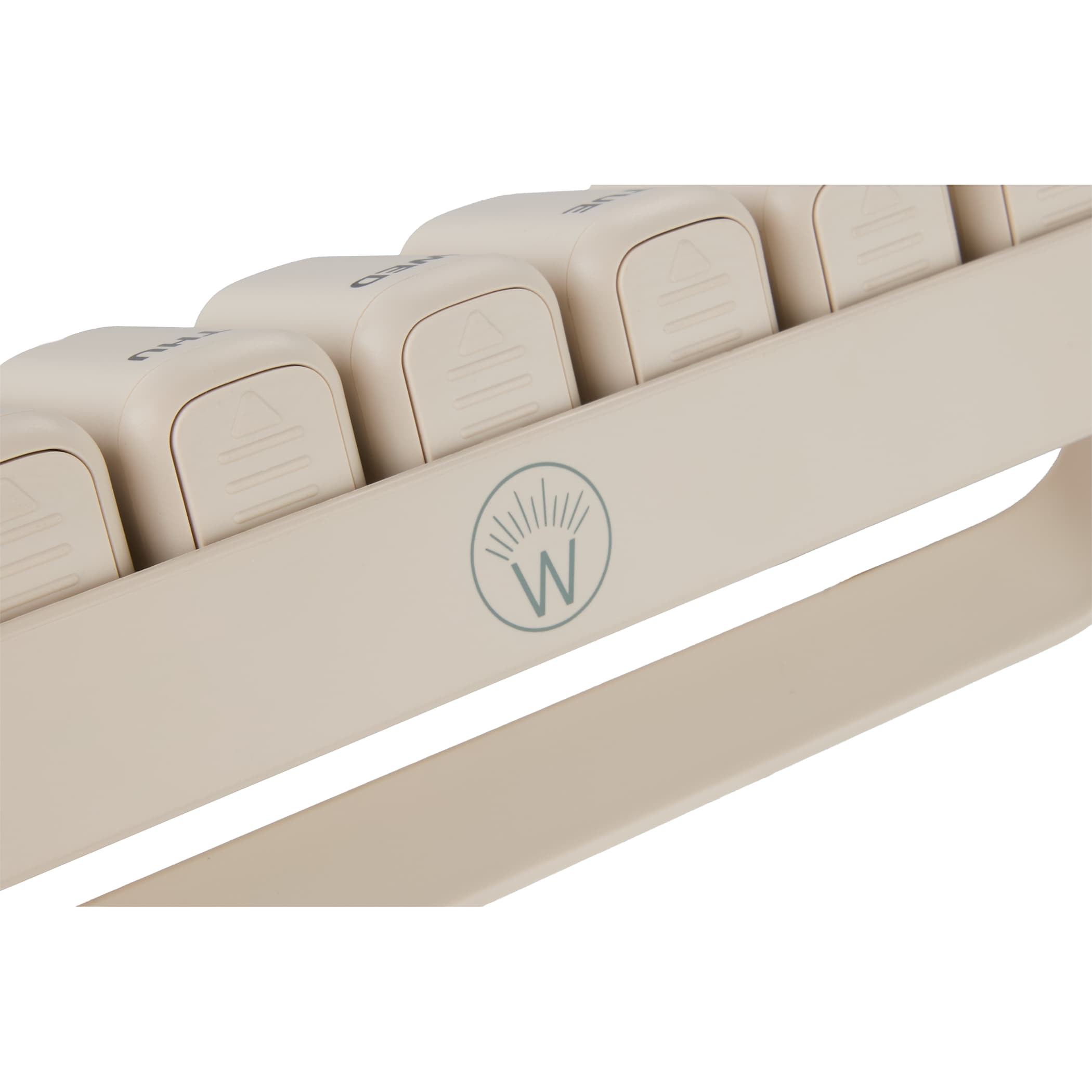 Cream Wellable™ Daily Pill and Supplement Organizer with seven removable sliding compartments, built-in daily reminder tracks, and compact rectangular design for organizing vitamins, supplements, or medications at home or while traveling.