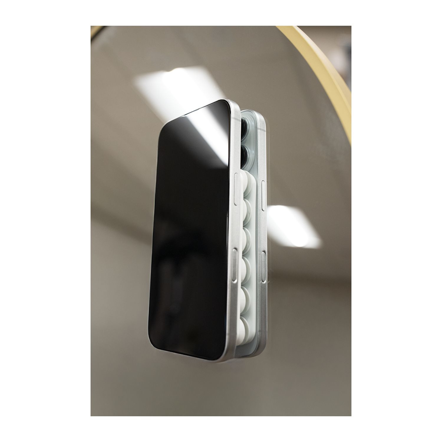 Black silicone suction and magnetic phone mount designed for hands-free device use on mirrors, gym equipment, or metal surfaces.