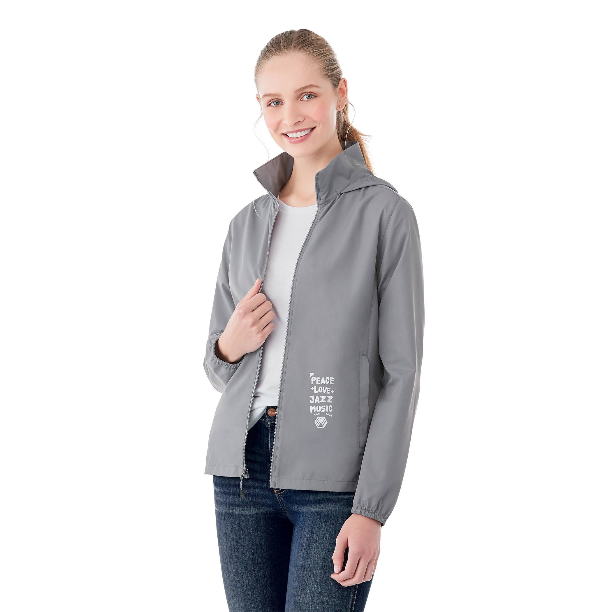 A Woman wearing Quarry Women’s Toba Packable Jacket in a lightweight outerwear design made from water-resistant polyester fabric, featuring a full front zipper, adjustable roll-away hood, articulated sleeves, and a slightly tapered waist for a feminine fit. The jacket has a smooth, matte finish and is designed for packable convenience, folding into its own pocket for easy travel and weather protection.
