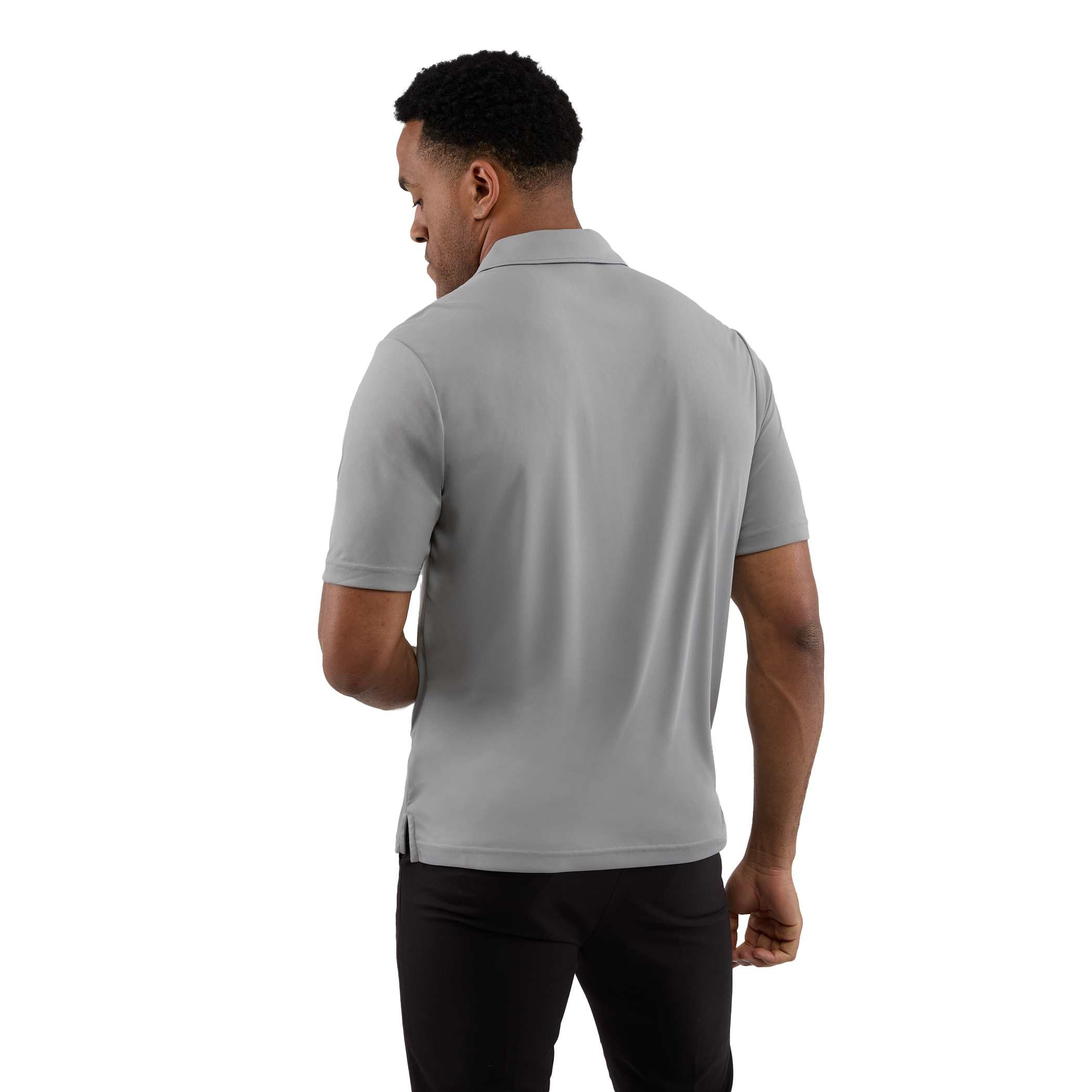 A man wearing a Quarry Men’s Dara Recycled Tech Polo made from structured recycled polyester fabric during an outdoor event. The short-sleeve polo features a modern two-snap button placket, clean snag-resistant texture, and an athletic fit, showcasing its use as professional corporate apparel.