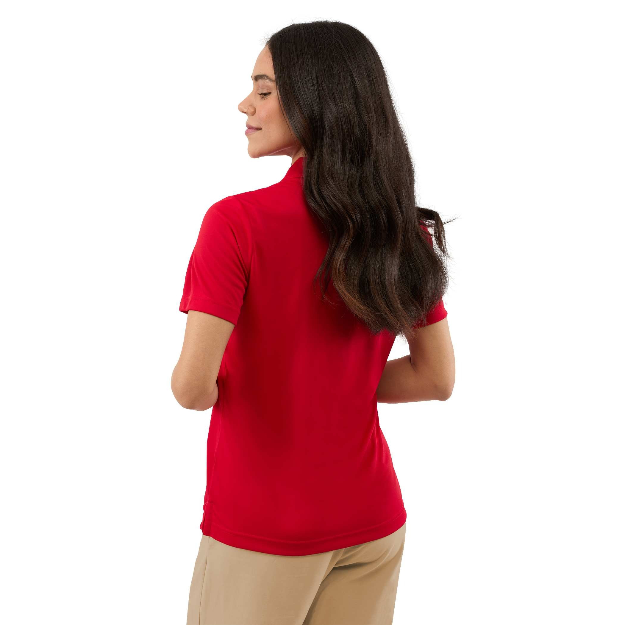 A woman wearing a Team Red Women’s Dara Recycled Tech Polo made from structured recycled polyester fabric during an outdoor event. The short-sleeve polo features a modern two-snap button placket, clean snag-resistant texture, and an athletic fit, showcasing its use as professional corporate apparel.