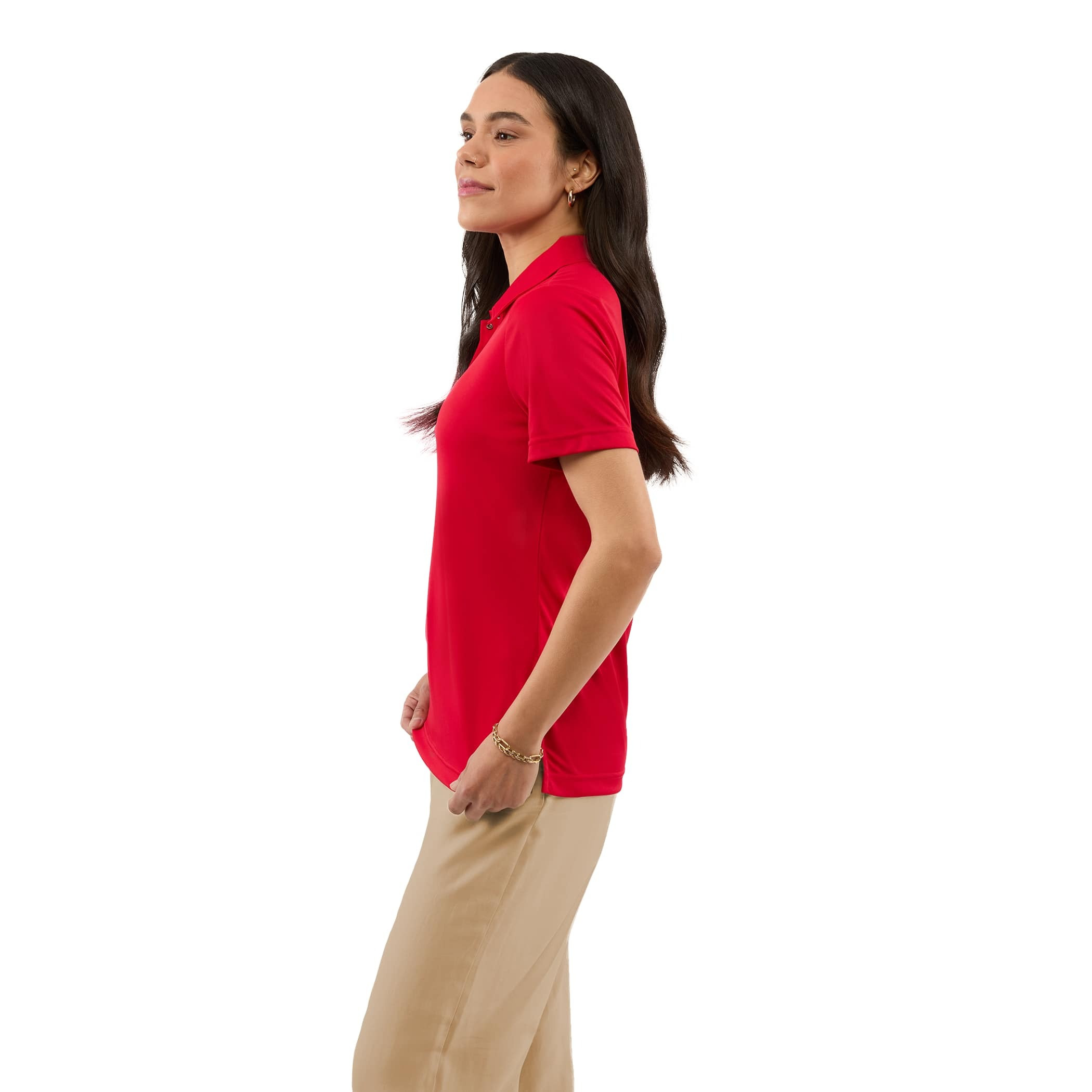 A woman wearing a Team Red Women’s Dara Recycled Tech Polo made from structured recycled polyester fabric during an outdoor event. The short-sleeve polo features a modern two-snap button placket, clean snag-resistant texture, and an athletic fit, showcasing its use as professional corporate apparel.