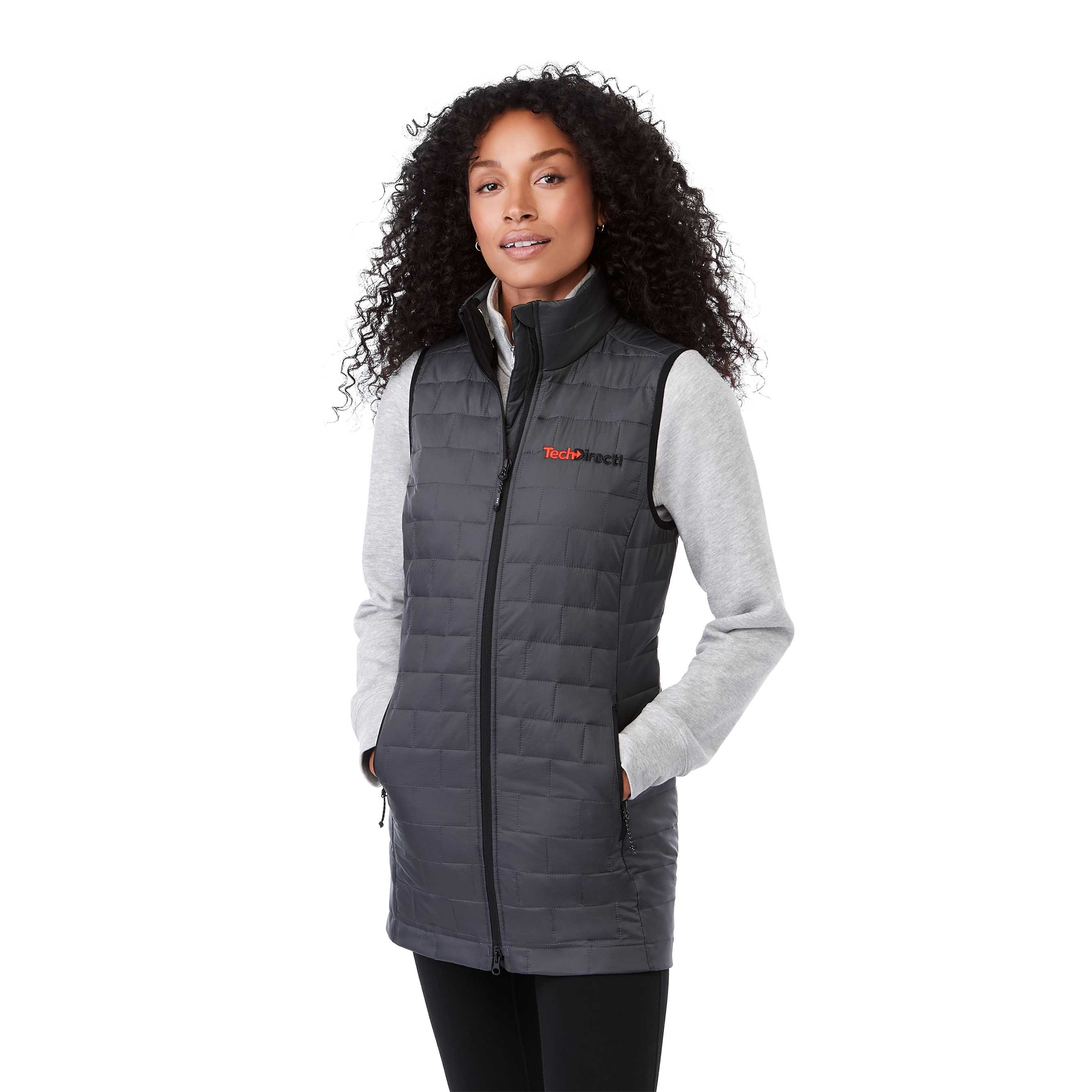 A woman wearing the Women's Telluride Packable Insulated Vest in Gray Storm, featuring a lightweight quilted nylon ripstop shell, full-zip front, stand collar, and zippered pockets, designed for comfortable layering and everyday outdoor wear.