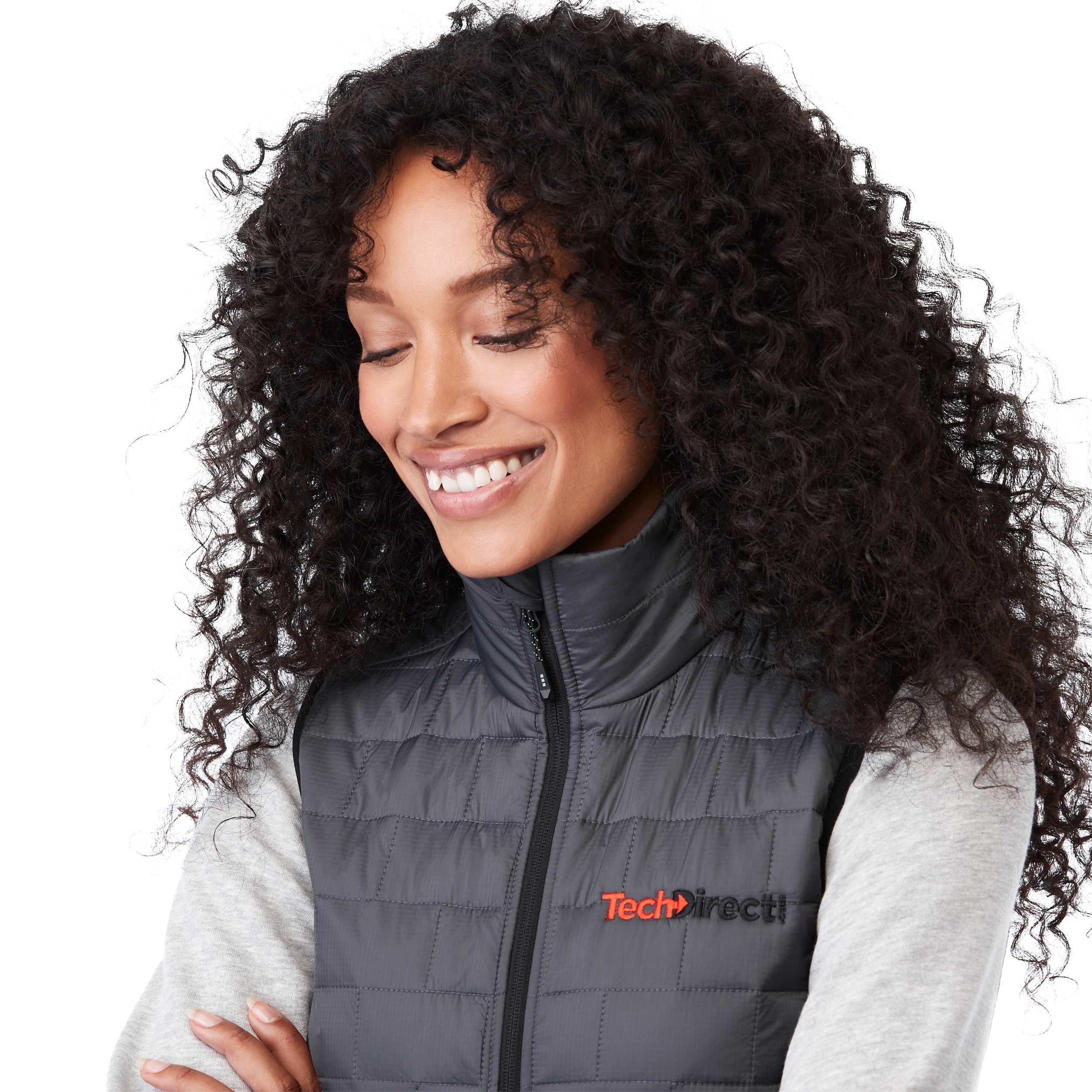 A woman wearing the Women's Telluride Packable Insulated Vest in Gray Storm, featuring a lightweight quilted nylon ripstop shell, full-zip front, stand collar, and zippered pockets, designed for comfortable layering and everyday outdoor wear.