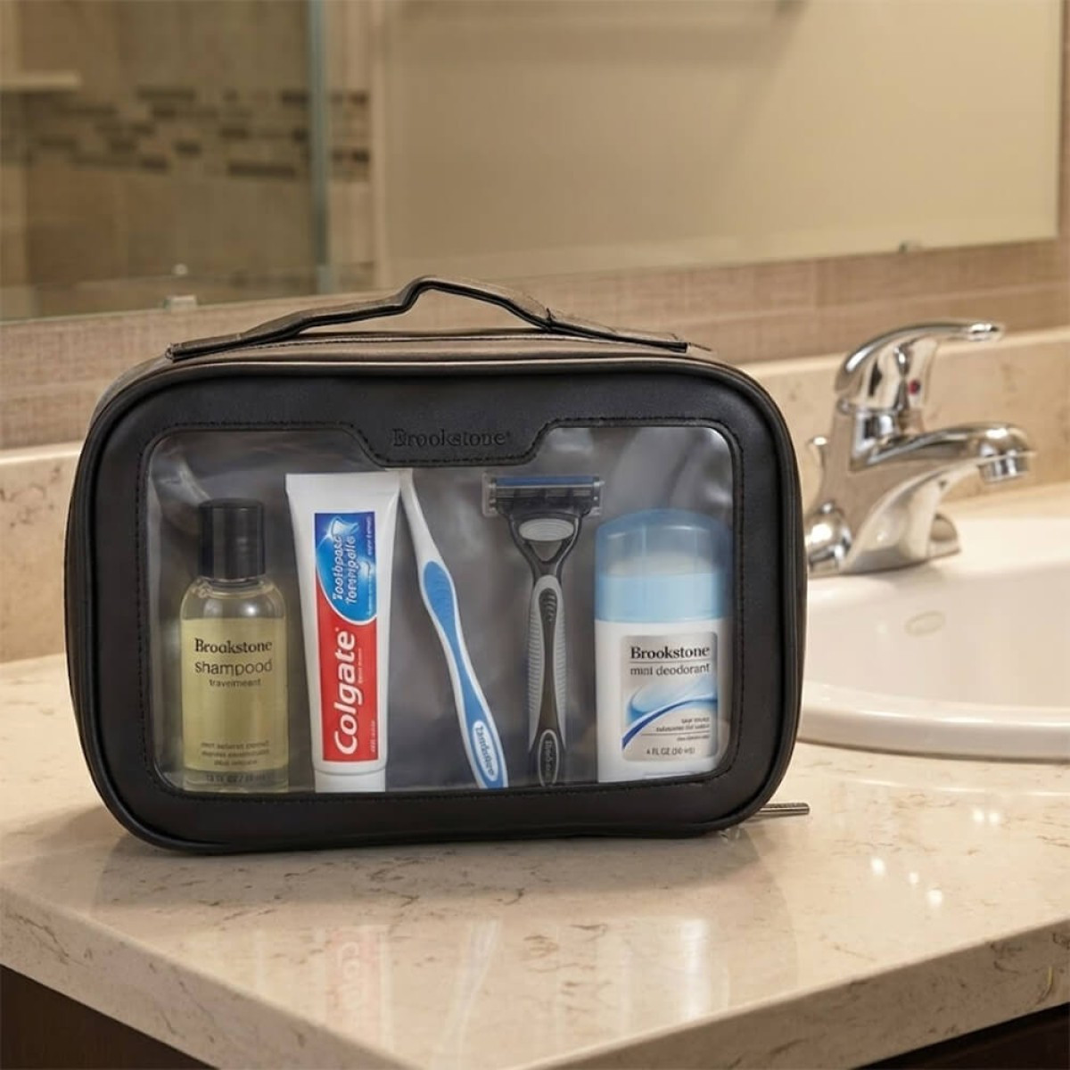 Brookstone 3 Piece Toiletry Kit featuring a sleek black vegan leather travel organizer set, including a main zippered pouch with transparent TPU side panels and two additional matching accessory pouches, designed for neatly storing toiletries and travel essentials.