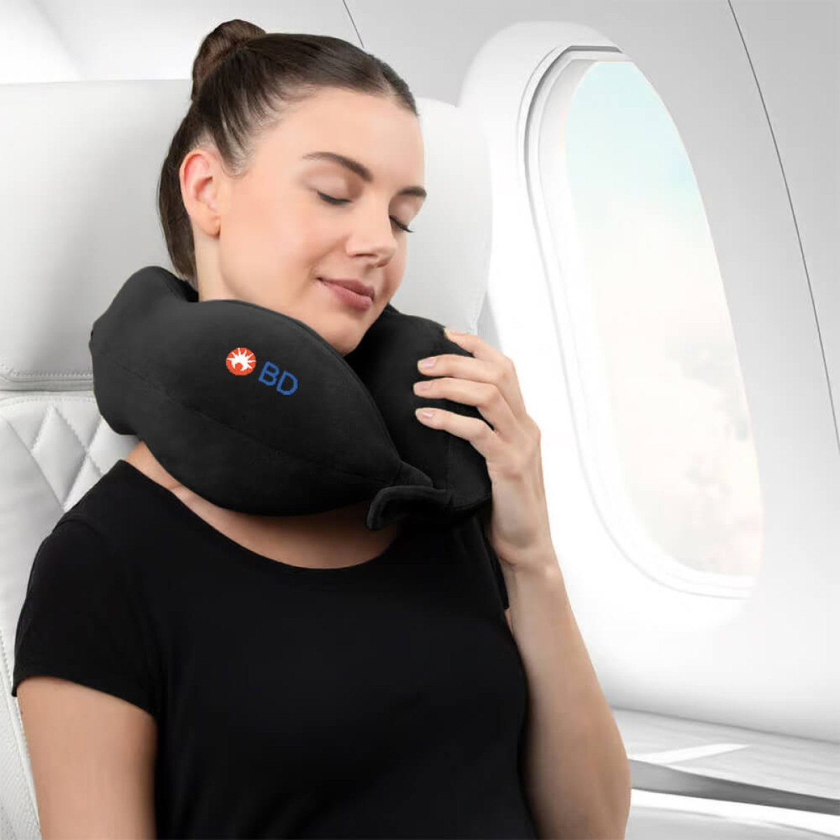 Brookstone Ultra Foam Memory Foam Neck Pillow in black with a U-shaped ergonomic design, featuring a soft fleece cover and supportive memory foam core for comfortable neck and head support during travel.