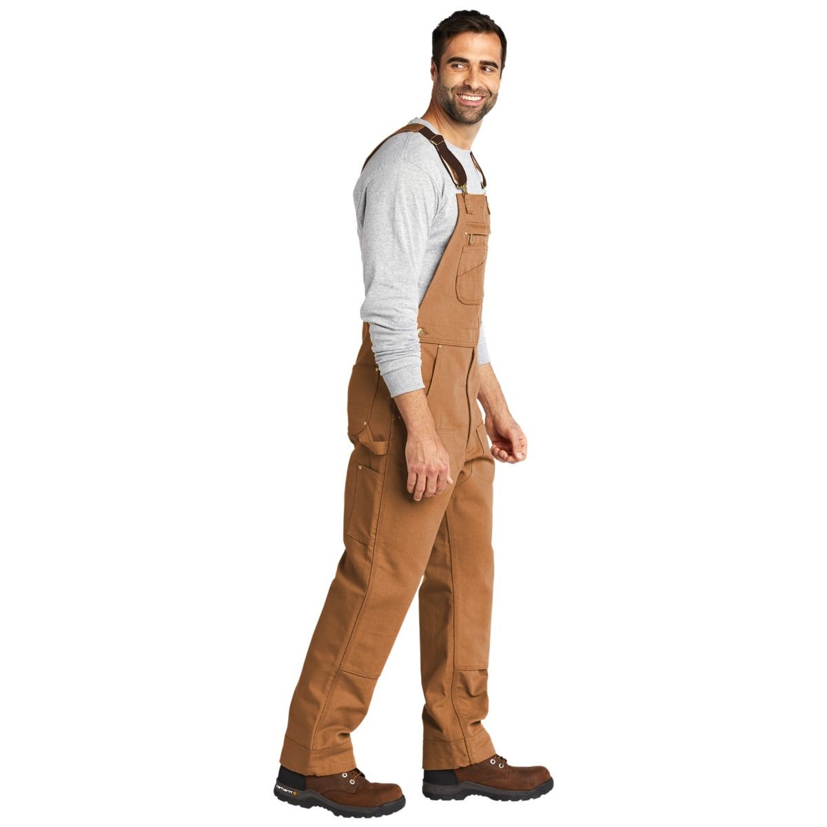 Carhartt Brown Carhartt® Duck Unlined Bib Overalls, featuring durable heavyweight cotton duck canvas, adjustable elastic suspenders, multiple utility pockets, double-front reinforced knees, and a relaxed fit designed for construction, job sites, and everyday workwear.