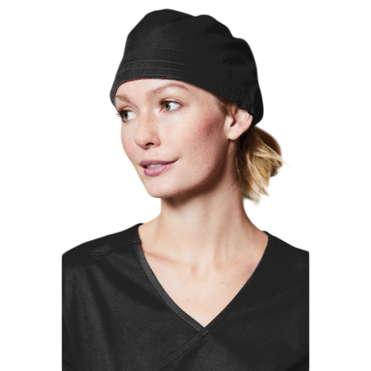 A woman wearing a Black WonderWink® WorkFlex™ Scrub Cap, featuring a smooth poly-cotton blend with mechanical stretch, a back tie closure, covered elastic band, and a classic one-size-fits-most design for healthcare professionals, medical settings, and everyday clinical wear.