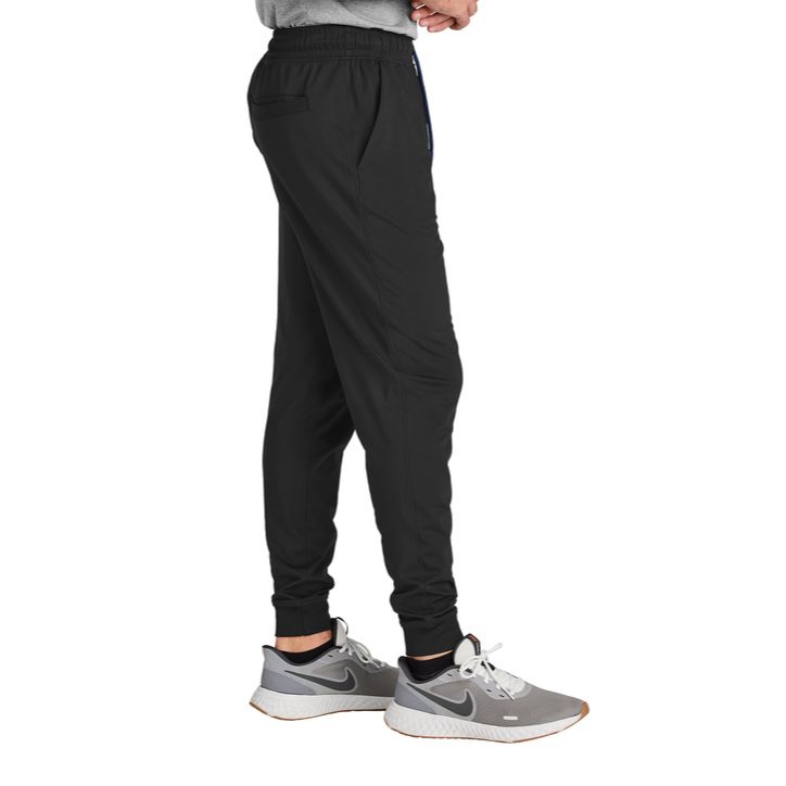 Black Sport-Tek® Sport-Wick® Stretch Jogger, featuring lightweight moisture-wicking stretch fabric, an elastic waistband with adjustable drawcord, tapered legs with elastic cuffs, and zippered side pockets for training, travel, and everyday active wear.