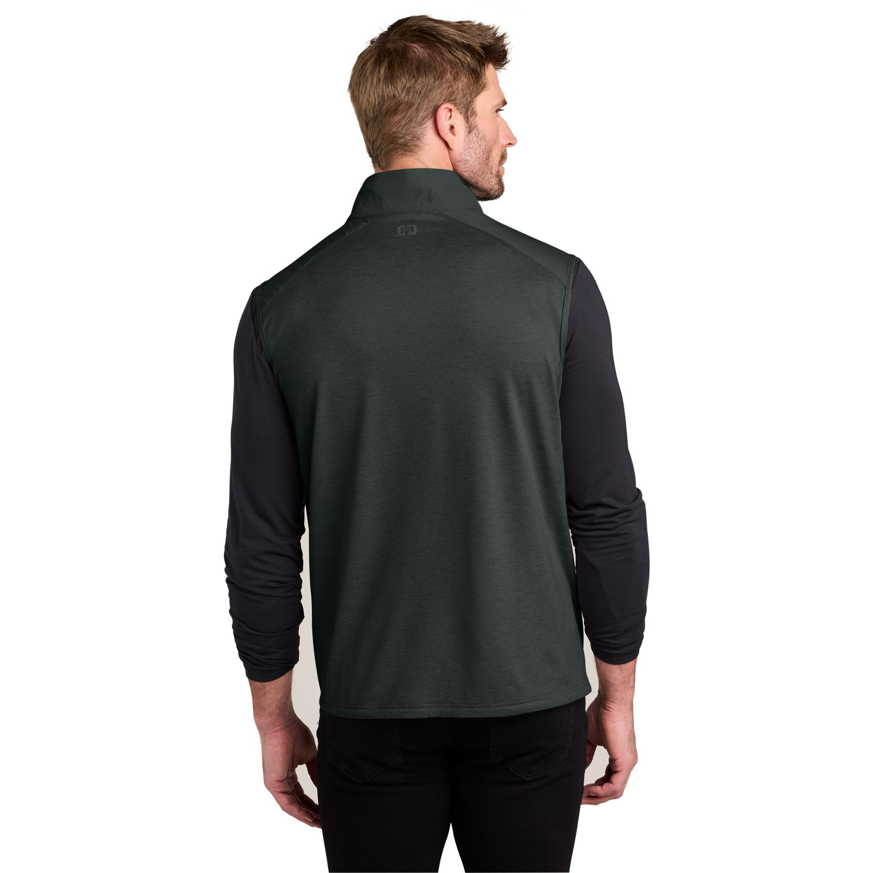 Blacktop OGIO® Driveline Hybrid Vest a lightweight hybrid vest with a water-repellent quilted front and back, moisture-wicking stretch knit side panels, stand collar, full-length zipper, zippered hand pockets, and a 3D silicone OGIO logo, designed for layering, golf, travel, work, and everyday outdoor wear.