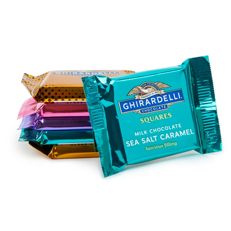 Ghirardelli® Squares Jingle Treats Ornament in a festive ornament-shaped gift box with vibrant full-color holiday graphics, filled with four assorted Ghirardelli® Chocolate Squares, designed for holiday gifting and seasonal celebrations.