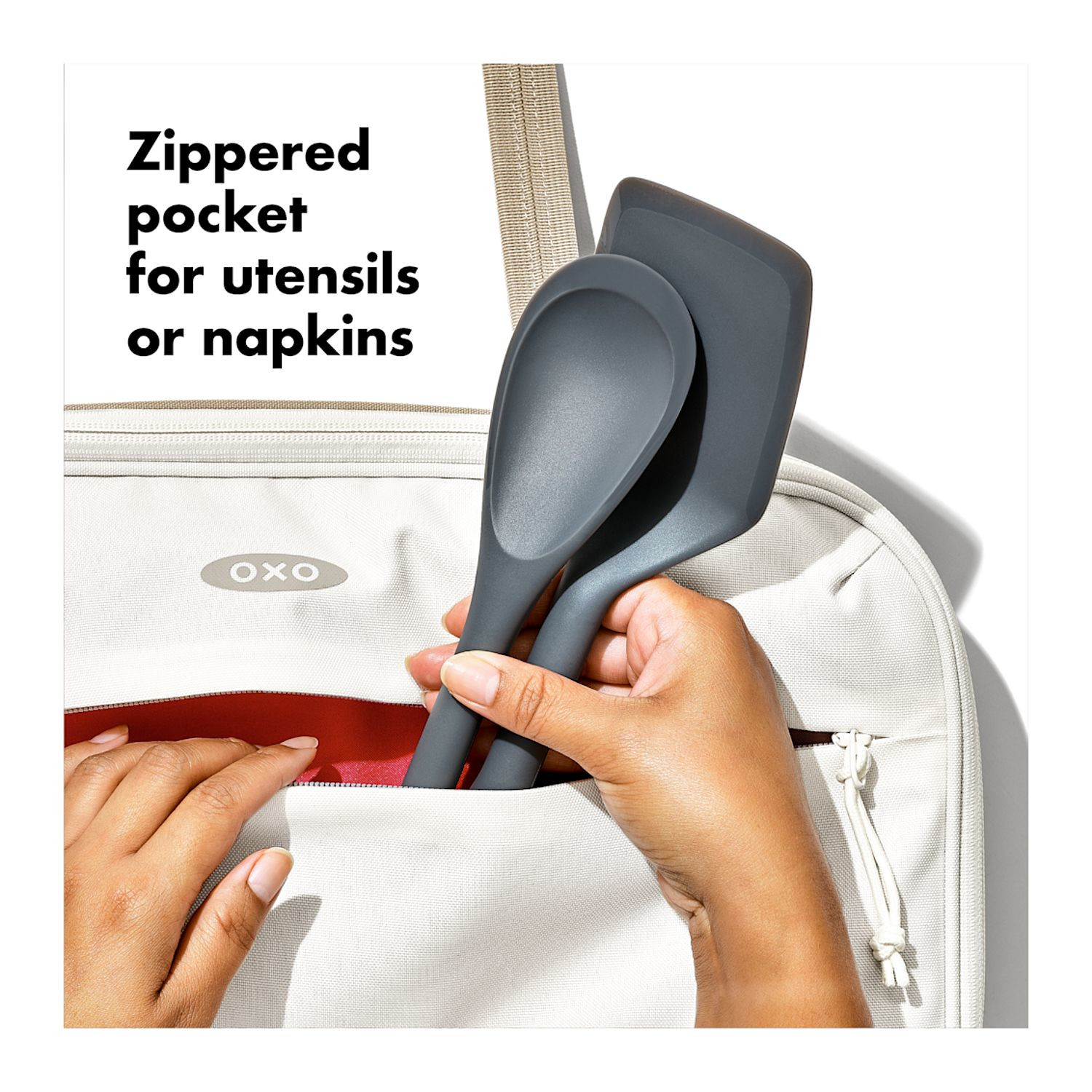 Tan OXO Good Grips Insulated Bakeware Carrier with durable exterior fabric, insulated interior with aluminum lining, generous carry handles, and a front zippered pocket, designed to transport 9 x 13-inch bakeware and keep hot or cold dishes at temperature during potlucks, parties, and family gatherings.