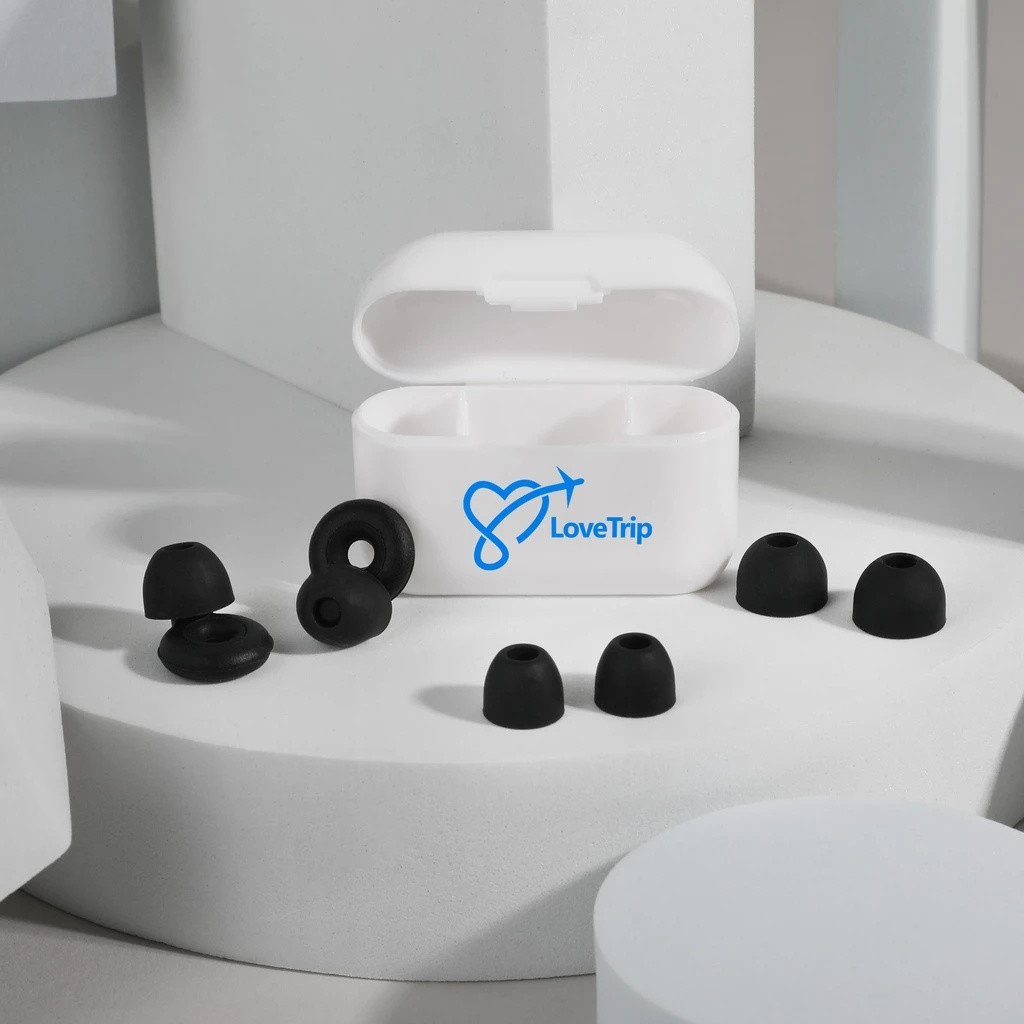 White and black loop-style silicone earplugs with a recycled plastic storage case and replacement ear tips for comfortable travel, studying, relaxation, and sleep.