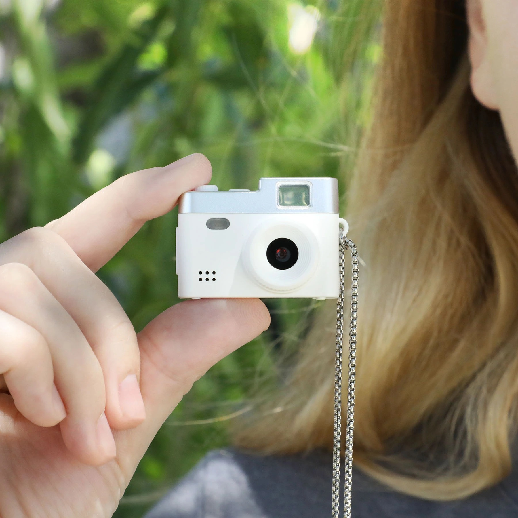 White Cutie Cam Mini Camera, compact portable camera with a fun mini design, featuring a small display and simple controls for capturing photos and 1080p video.