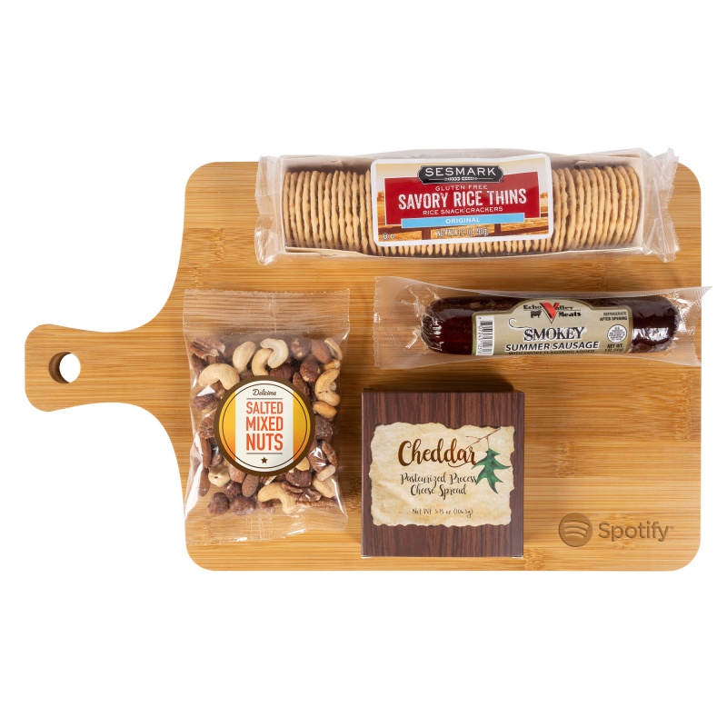 Wood bamboo charcuterie board with cheddar cheese spread, summer sausage, mixed salted nuts, and savory rice thin crackers, featuring a convenient handle for transport.