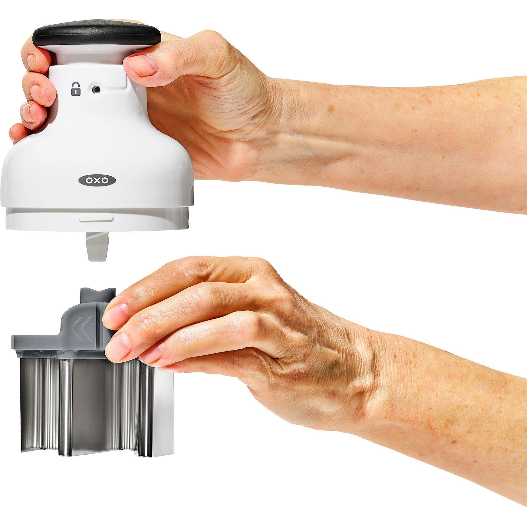 White OXO Good Grips Chopper, white plastic food chopper with a clear measurement-marked catcher cup and pump-action knob, featuring a rotating stainless steel blade for chopping vegetables, herbs, nuts, and other ingredients.