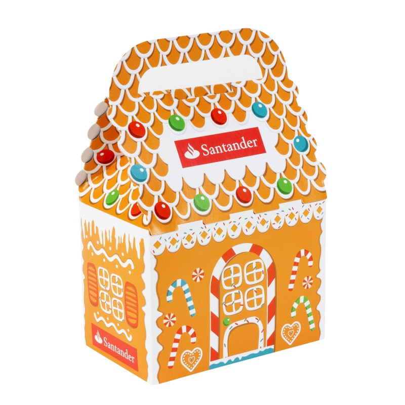 Gingerbread cookie decorating kit in a festive holiday house gift box with three gingerbread cookies, vanilla icing, and colorful candies for a fun seasonal activity.