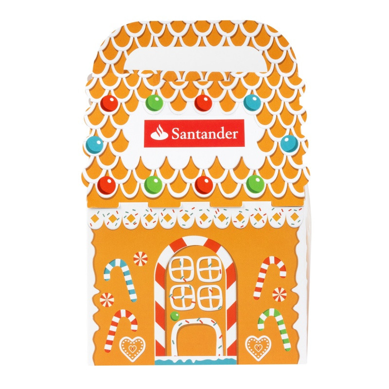 Gingerbread cookie decorating kit in a festive holiday house gift box with three gingerbread cookies, vanilla icing, and colorful candies for a fun seasonal activity.