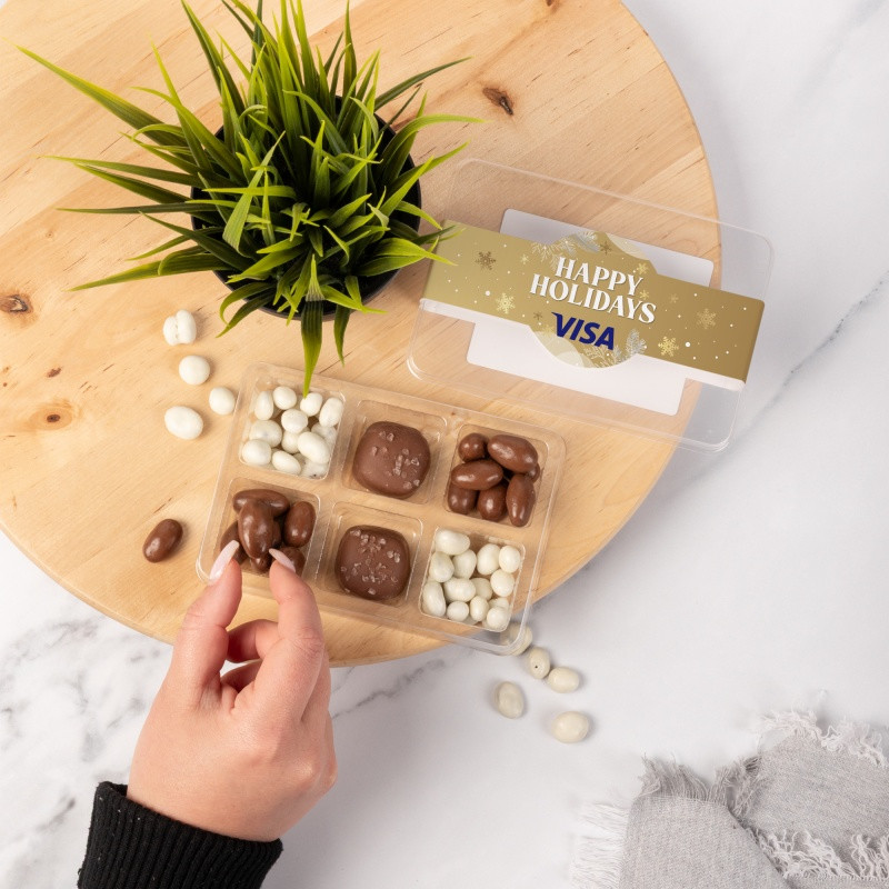 Clear mini tackle box filled with milk or dark chocolate sea salt caramels, chocolate-covered almonds, and yogurt-coated raisins, featuring six candy compartments and a full-color sleeve.