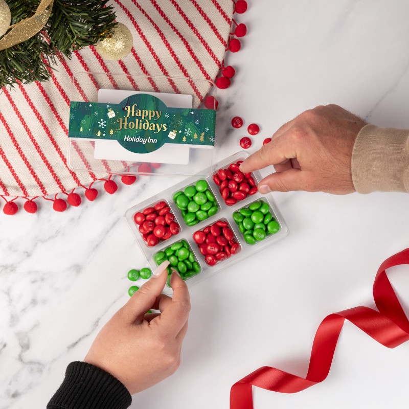Clear mini tackle box filled with colorful M&M'S® chocolate candies in six compartments and a customizable full-color sleeve.