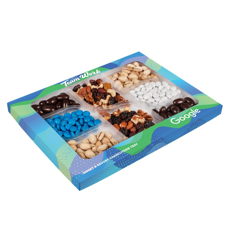 Custom Premium snack gift box featuring an assortment of Champions Mix, colorful M&M’S® candies, dark chocolate-covered almonds, and roasted salted pistachios. Packaged in a full-color, die-cut custom box with vibrant printed graphics, this sweet and savory snack collection is ideal for executive gifts, holiday appreciation, and client thank-you presents.